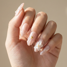 Hand with delicate nail art on a neutral background